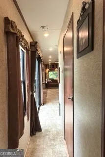 a view of hallway with a mirror and a glass door