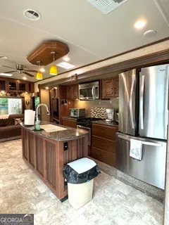 a kitchen with stainless steel appliances granite countertop a stove a sink and a refrigerator