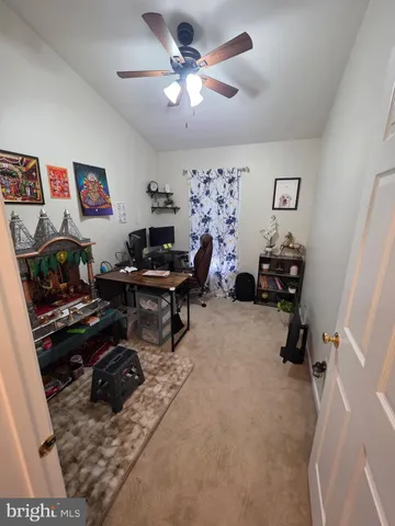 a view of a workspace with furniture and ceiling fan