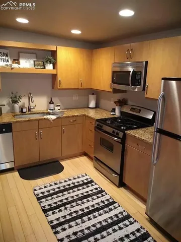 a kitchen with granite countertop a sink and a stove top oven