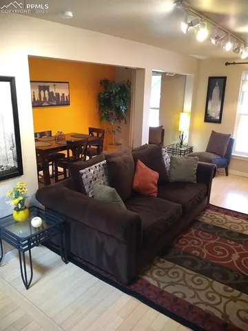 a living room with furniture and a flat screen tv with kitchen view
