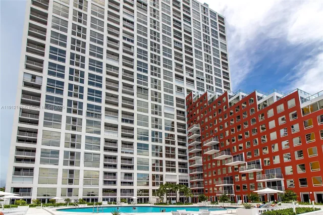 a large bed sitting in a bedroom next to a window