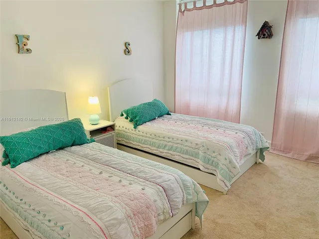 a living room with patio furniture and floor to ceiling windows