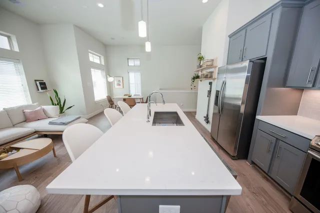a living room with furniture and a refrigerator