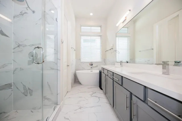 a spacious bathroom with a double vanity sink mirror and shower