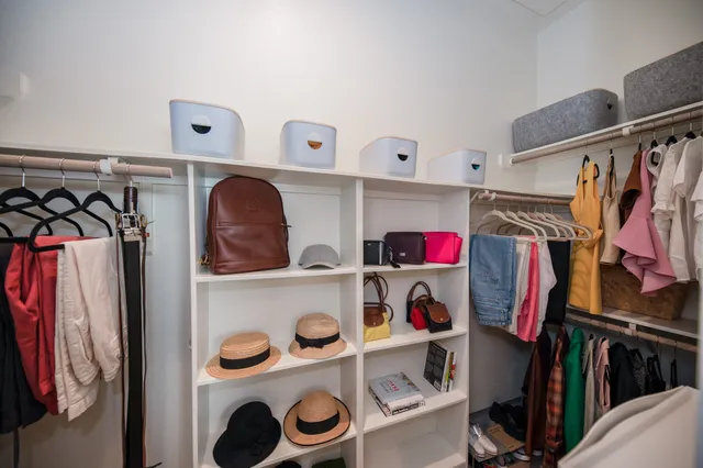 a view of walk in closet with clothes and shoes