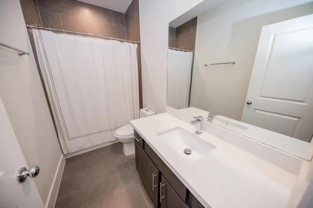 a bathroom with a sink a toilet and a mirror