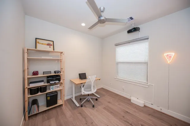 a view of a workspace with furniture and a window