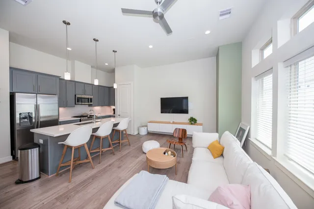 a living room with furniture kitchen view and a large window