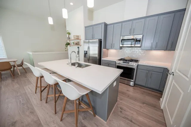 a kitchen with kitchen island a stove a table and chairs in it