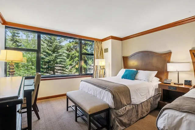 a bedroom with a bed and a large window