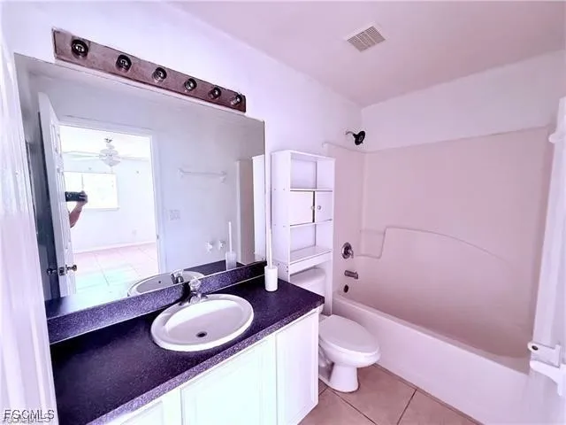 a bathroom with a granite countertop sink toilet a mirror and shower