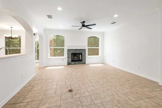 an empty room with windows and fireplace cabinet