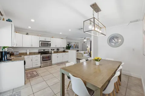 a kitchen with a table chairs and white cabinets