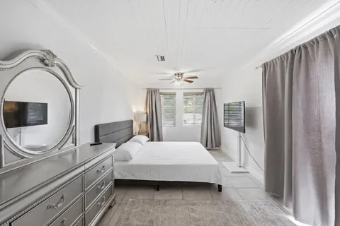 a bedroom with a large bed and a chandelier