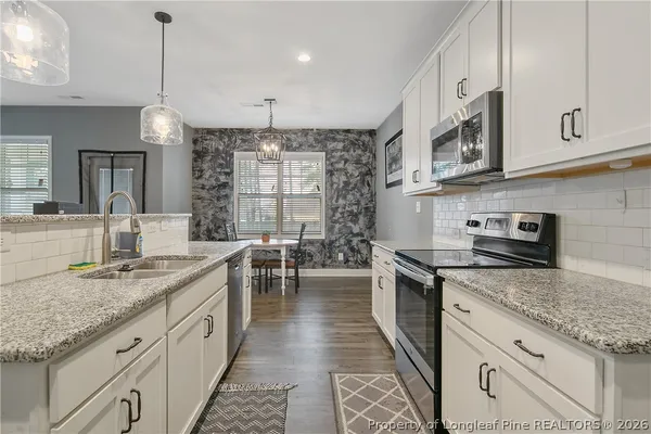 a kitchen with sink stove and cabinets