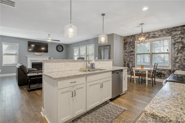 a kitchen with granite countertop white cabinets stainless steel appliances and a sink