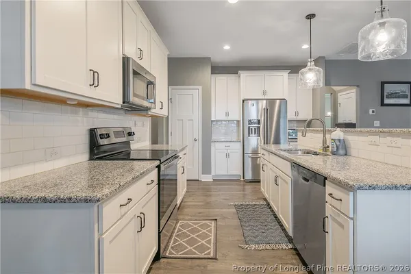 a kitchen with stainless steel appliances granite countertop a sink and a refrigerator