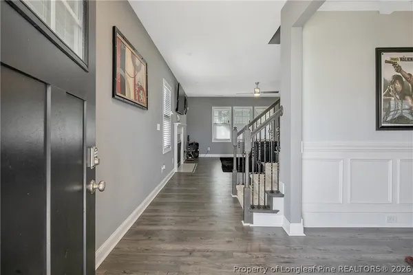 a view of a hallway with wooden floor and staircase