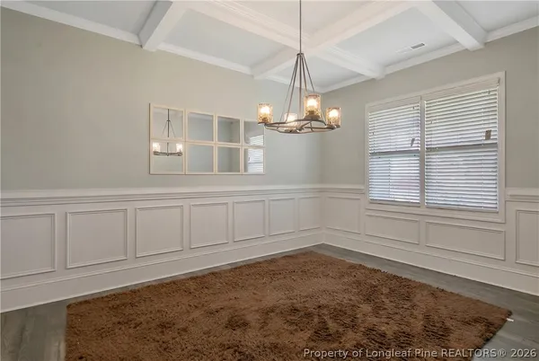 an empty room with wooden floor cabinet and windows