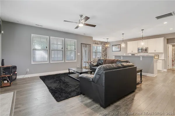 a living room with furniture and a wooden floor
