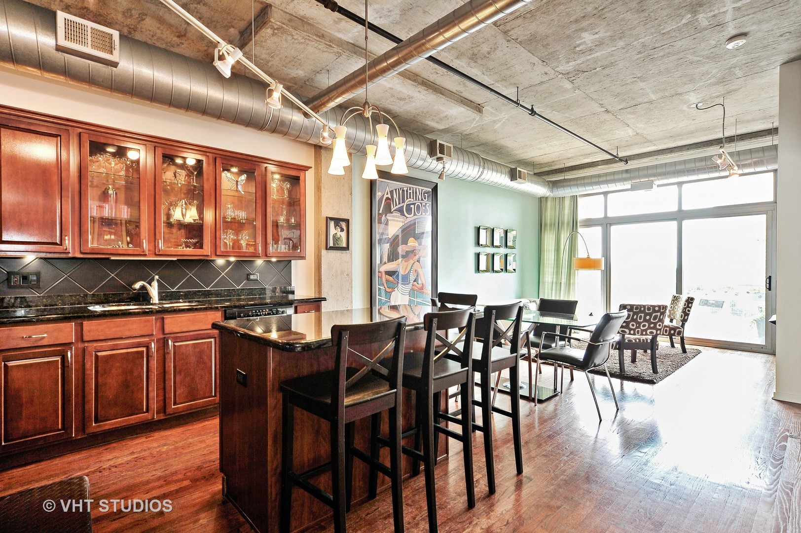 933 West Van Buren Street, Unit 612 Chicago, IL 60607 - Photo 7 of 17 a dining hall with stainless steel appliances granite countertop a stove a sink with a dining table and chairs