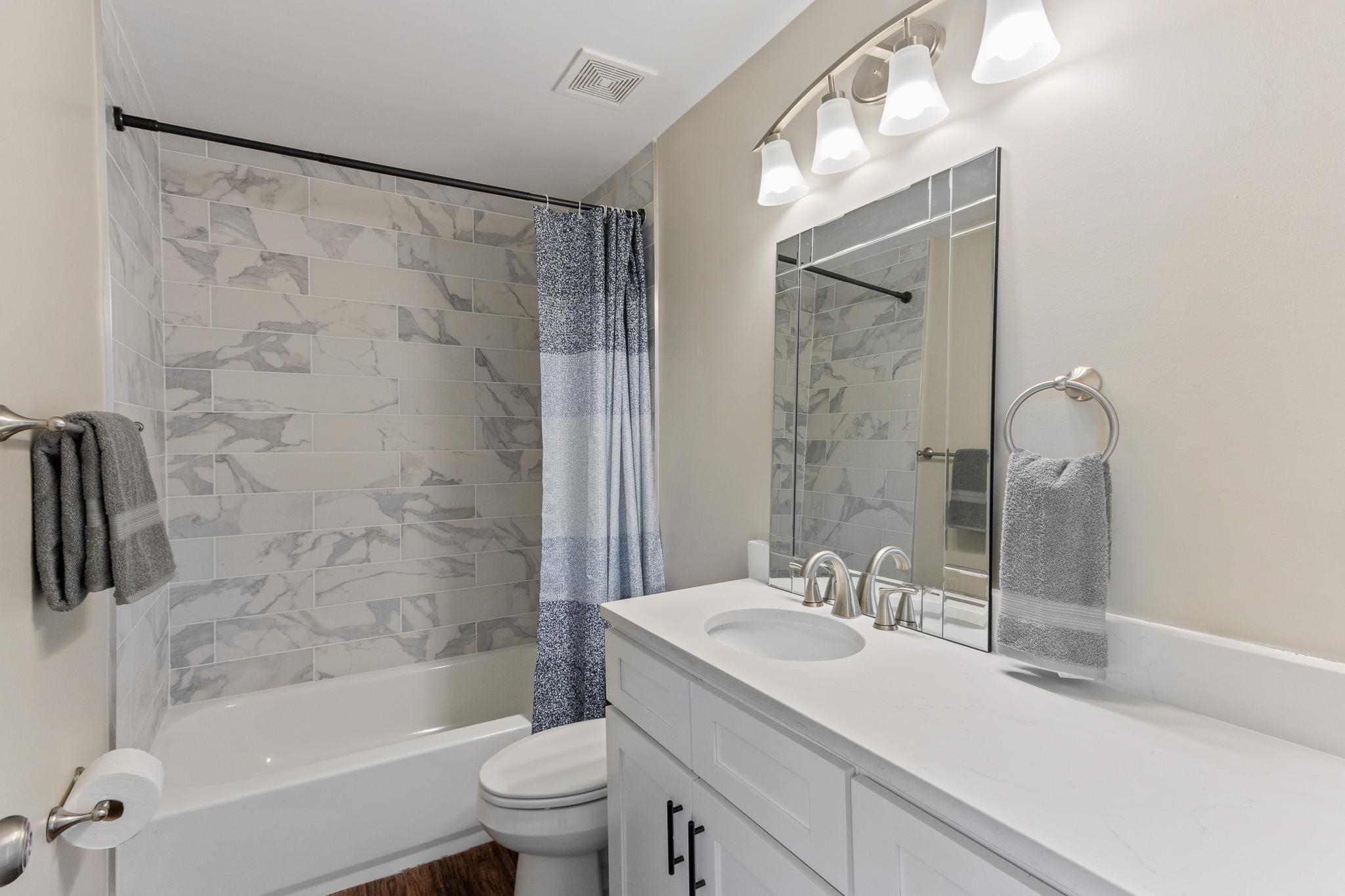 4775 Macon Road Memphis, TN 38122 - Photo 19 of 31 a bathroom with a granite countertop sink a toilet and shower