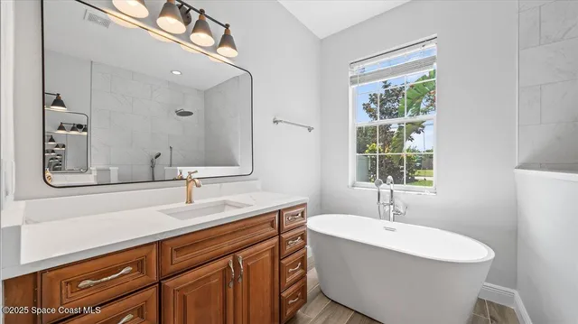 a bathroom with a double vanity sink a mirror and a bathtub