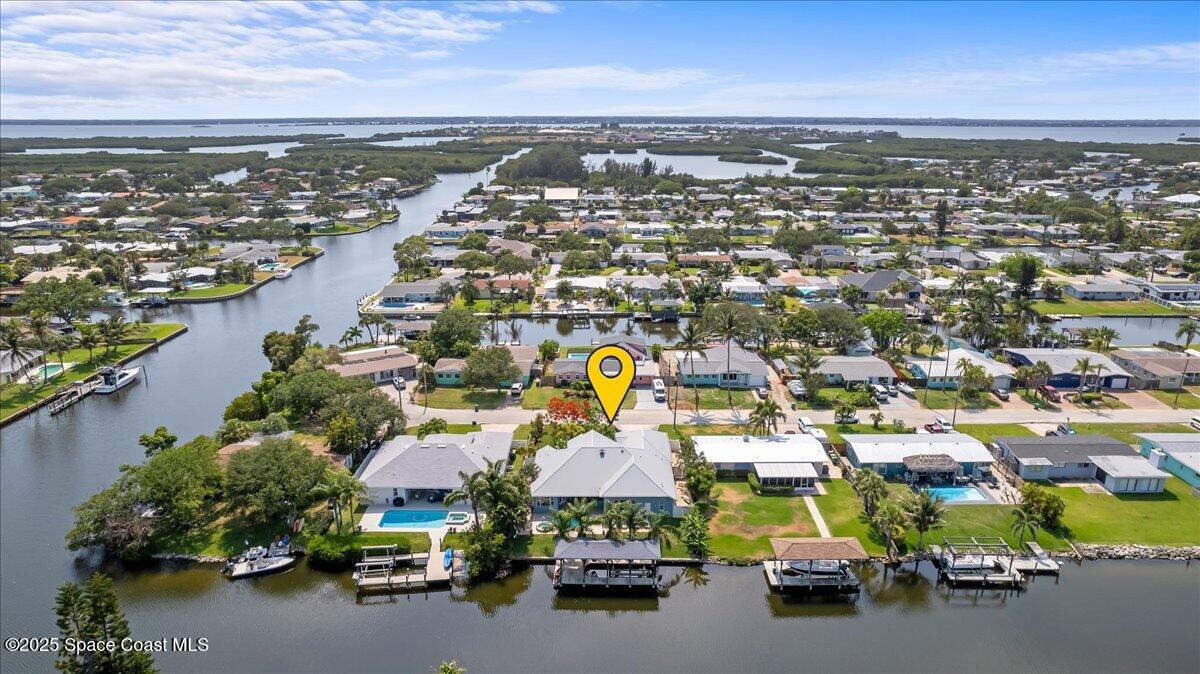 121 Boca Ciega Road Cocoa Beach, FL 32931 - Photo 3 of 50 an aerial view of a city with lots of residential buildings ocean and mountain view in back