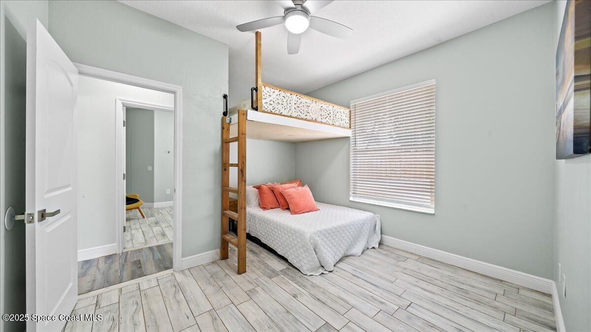 121 Boca Ciega Road Cocoa Beach, FL 32931 - Photo 35 of 50 a spacious bedroom with a bed and a chandelier