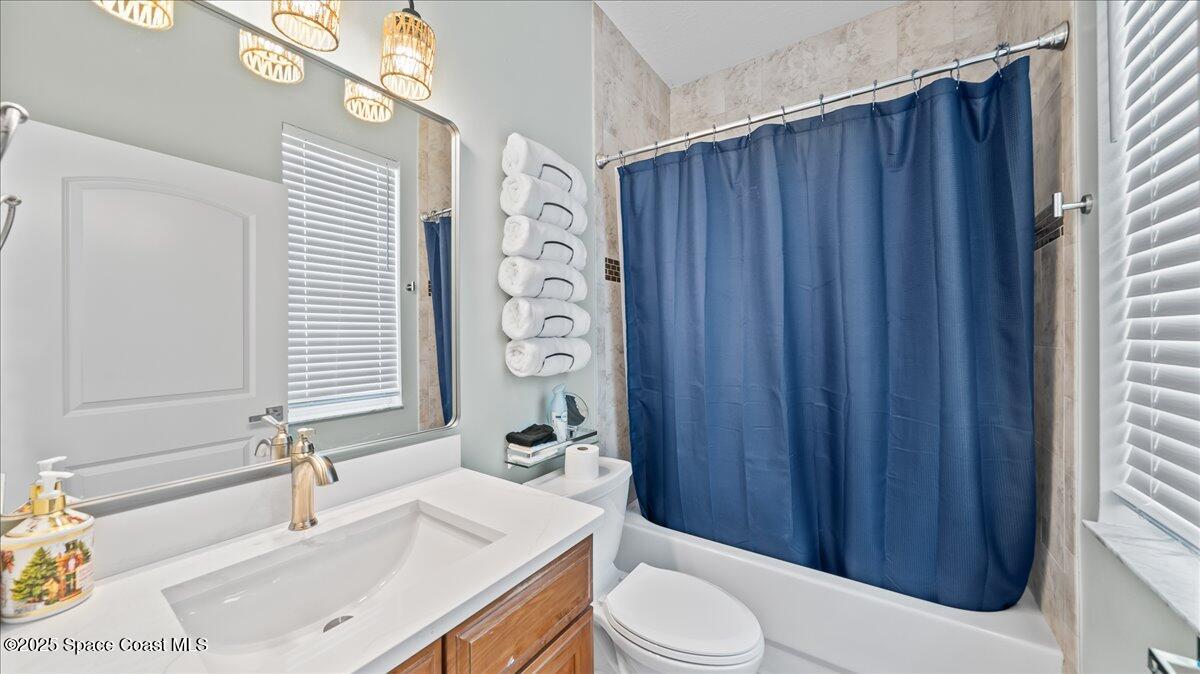 121 Boca Ciega Road Cocoa Beach, FL 32931 - Photo 36 of 50 a bathroom with a sink a toilet and shower curtain