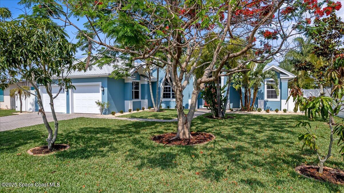 121 Boca Ciega Road Cocoa Beach, FL 32931 - Photo 42 of 50 a view of a house with a tree and plants