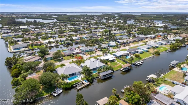 an aerial view of a city with lots of residential buildings ocean and mountain view in back