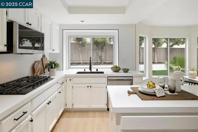 a kitchen with white cabinets and appliances