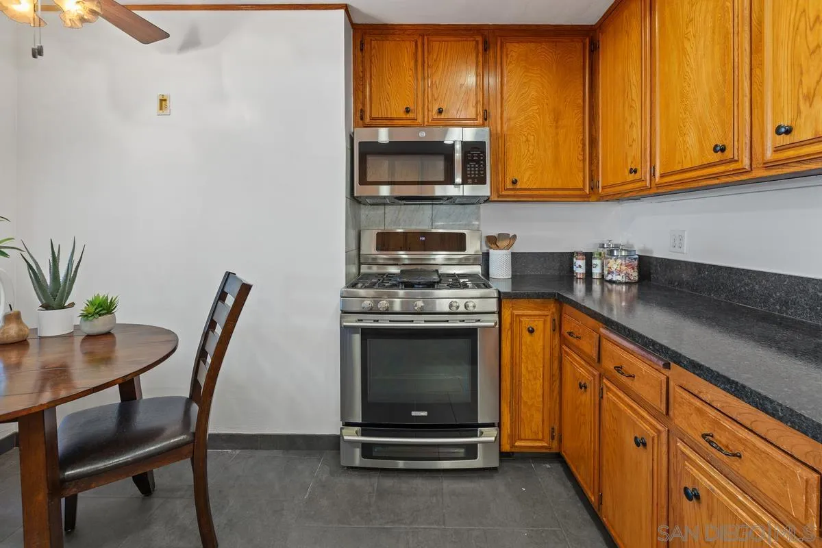 2707 Sweetwater Road Spring Valley, CA 91977 - Photo 14 of 30 a kitchen with granite countertop a stove a sink and a microwave