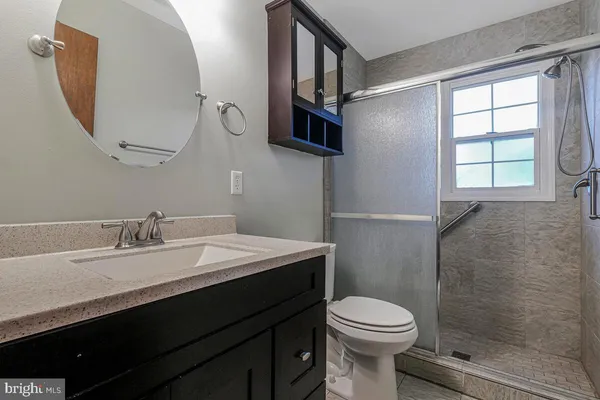a bathroom with a sink a toilet and a mirror
