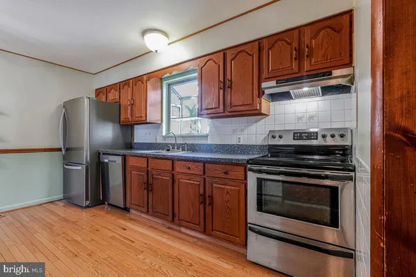 a kitchen with stainless steel appliances granite countertop a stove microwave and refrigerator
