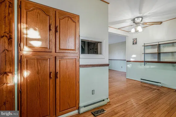 a view of a kitchen with wooden floor and a kitchen space with a sink