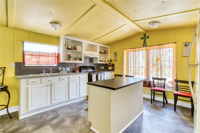 a kitchen with stainless steel appliances granite countertop sink stove and cabinets