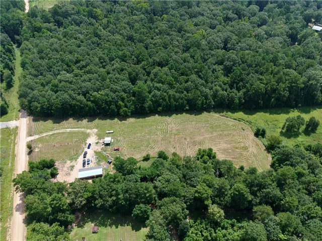 an aerial view of a house with a yard and lake view