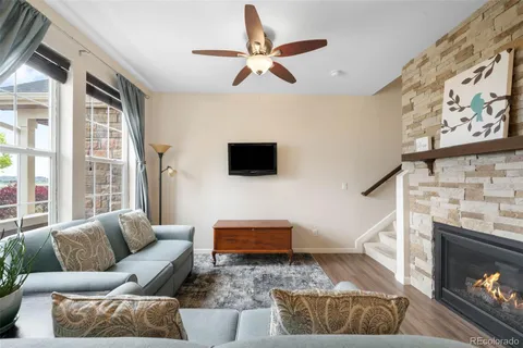 a living room with furniture a flat screen tv and a fireplace