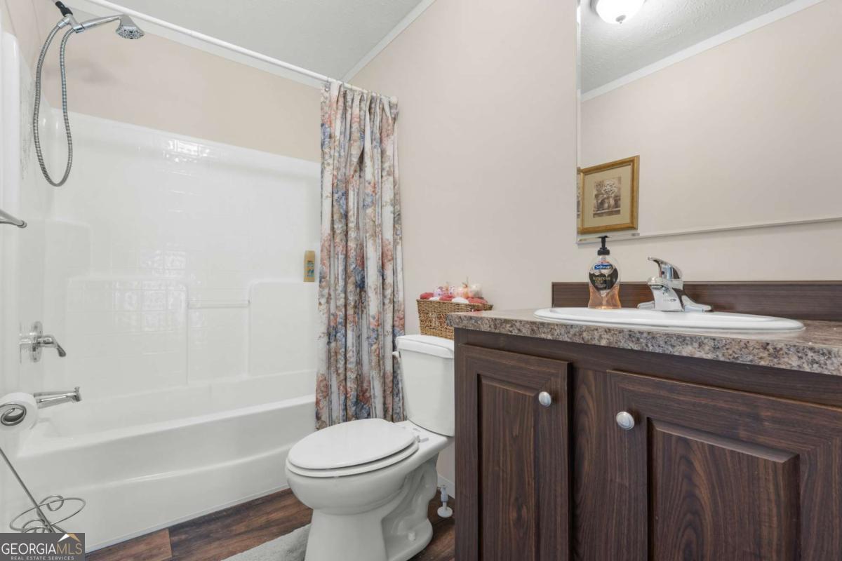 3516 Bennetts Landing Road Millen, GA 30442 - Photo 20 of 34 a bathroom with a granite countertop sink a toilet and shower