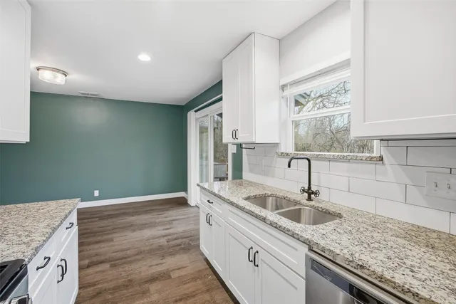 a kitchen with sink cabinets and wooden floor