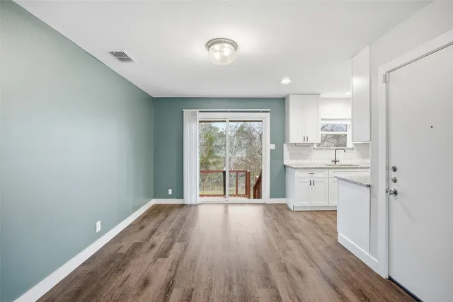 a view of a kitchen with wooden floor and a window