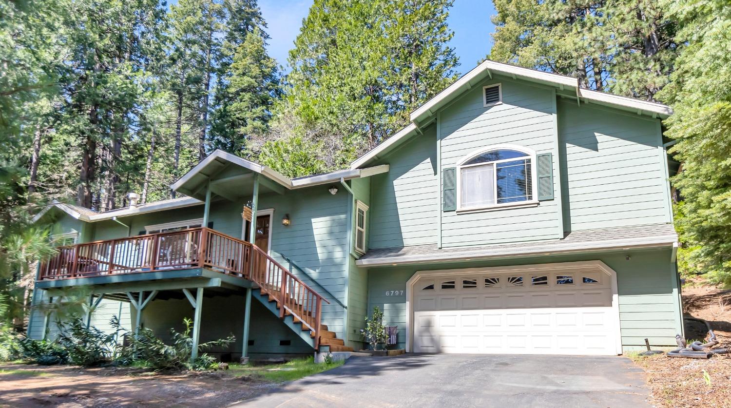 a view of a white house with large windows and a small yard