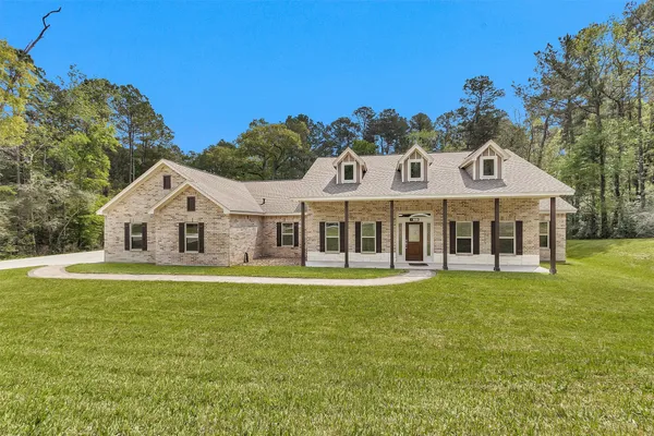 a front view of a house with a yard balcony and seating area