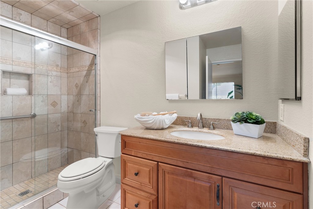 22232 South Vermont Avenue, Unit 102B Torrance, CA 90502 - Photo 17 of 26 a bathroom with a granite countertop toilet sink and mirror