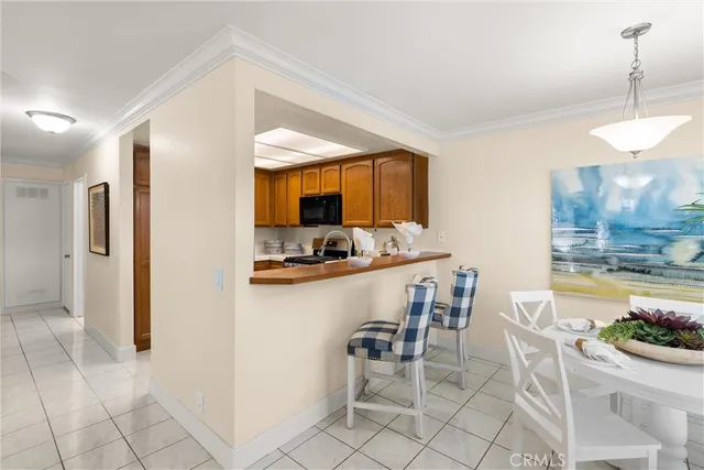 a kitchen with a dining table chairs and refrigerator