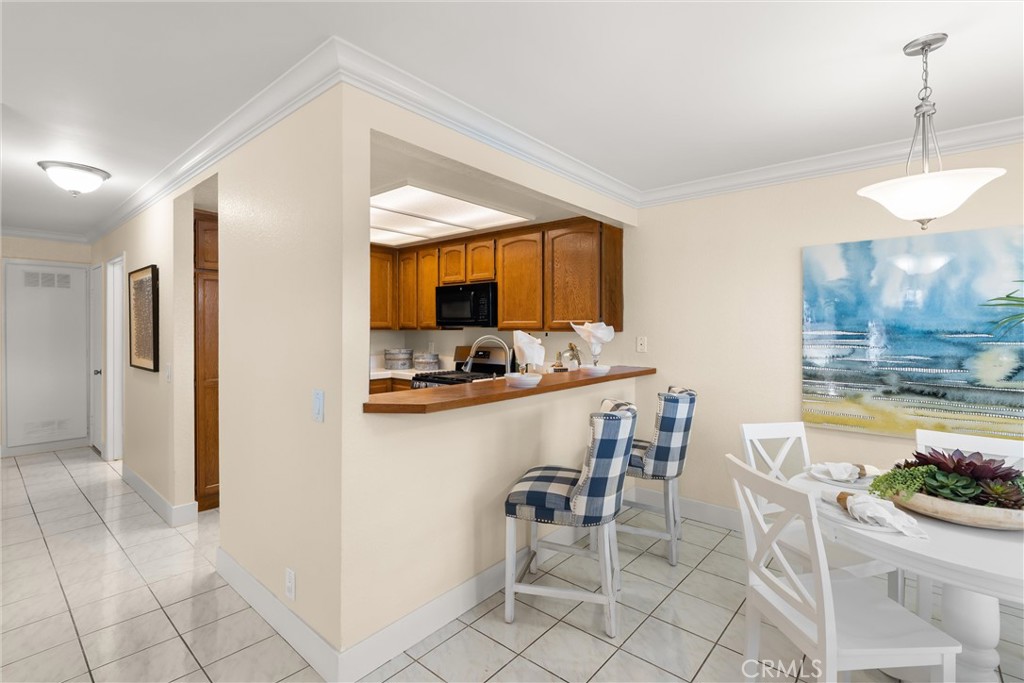 22232 South Vermont Avenue, Unit 102B Torrance, CA 90502 - Photo 2 of 26 a kitchen with a dining table chairs and refrigerator