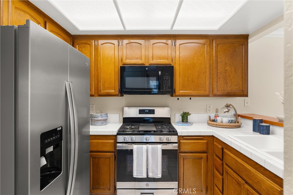 22232 South Vermont Avenue, Unit 102B Torrance, CA 90502 - Photo 10 of 26 a kitchen with stainless steel appliances granite countertop a stove a sink and a microwave